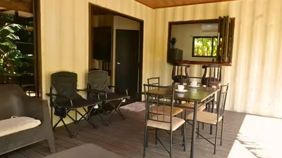 a patio with a table and chairs on a porch at M&M Container Home in Sardinal