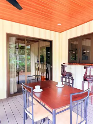 a wooden dining table and chairs on a deck at M&M Container Home in Sardinal