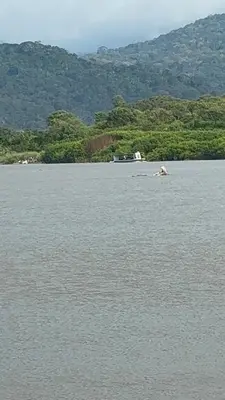 a large body of water with mountains in the background at Camping y hospedaje playa azul in Tarcoles