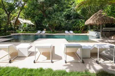 a table and chairs next to a swimming pool at Ocean view Jungle Nest - 2min from the beach in Santa Teresa Beach