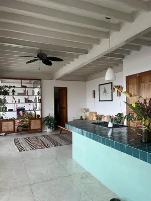 a living room with a ceiling fan and a counter at Ocean view Jungle Nest - 2min from the beach in Santa Teresa Beach