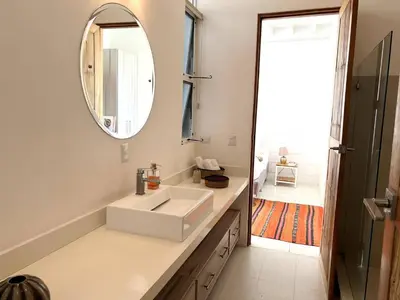 a bathroom with a white sink and a mirror at Ocean view Jungle Nest - 2min from the beach in Santa Teresa Beach