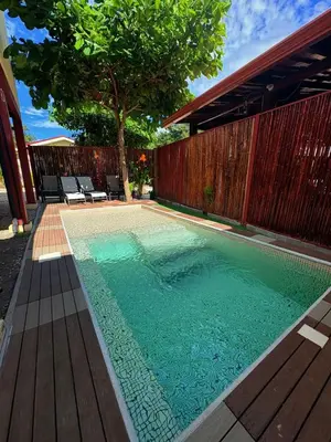 a swimming pool in a backyard with a wooden fence at Apartamento Villas Luna in Potrero