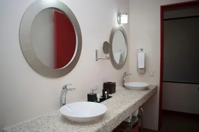 a bathroom with two sinks and two mirrors at Rancho Humo Estancia in Puerto Humo