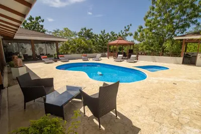 a swimming pool with chairs and a gazebo at Rancho Humo Estancia in Puerto Humo