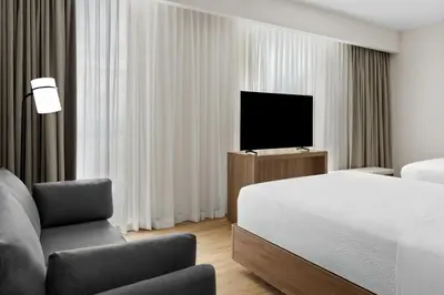 a bedroom with a bed and a tv and a chair at Residence Inn by Marriott San Jose Alajuela el Coyol in San José