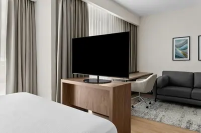 a hotel room with a television and a chair at Residence Inn by Marriott San Jose Alajuela el Coyol in San José