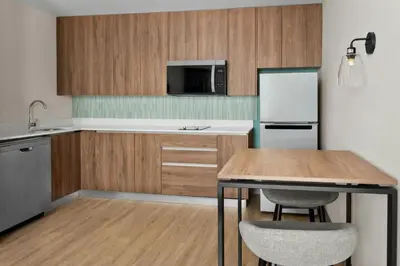 a kitchen with a table and a refrigerator at Residence Inn by Marriott San Jose Alajuela el Coyol in San José