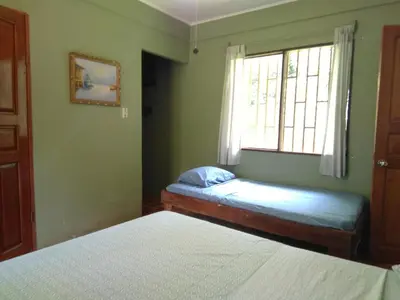 a bedroom with two beds and a window at CASA QUEPOS- Private House & Farm For 8-31 Guests in Quepos