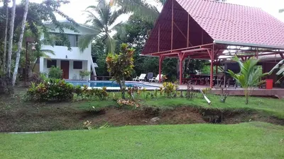 a villa with a swimming pool and a house at CASA QUEPOS- Private House & Farm For 8-31 Guests in Quepos