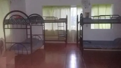 a room with three bunk beds in a room at CASA QUEPOS- Private House & Farm For 8-31 Guests in Quepos