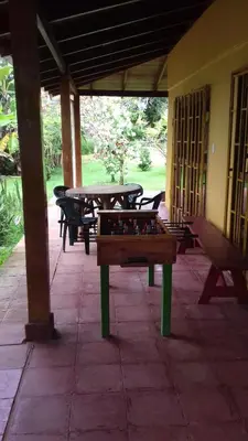 a ping pong table on a patio with tables and benches at CASA QUEPOS- Private House & Farm For 8-31 Guests in Quepos