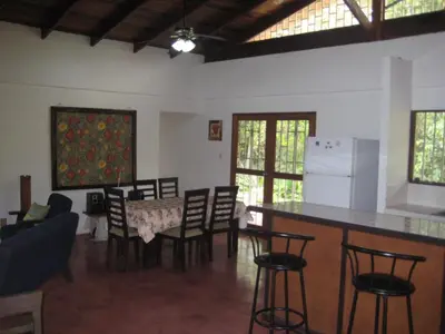 a kitchen and living room with a table and chairs at CASA QUEPOS- Private House & Farm For 8-31 Guests in Quepos