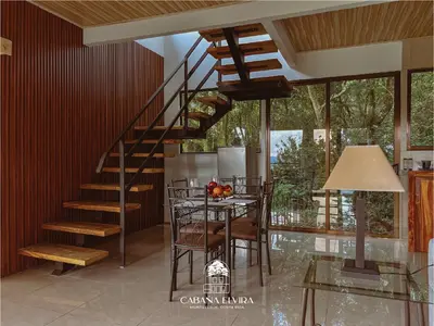 a staircase in a living room with a table and chairs at Cabaña Elvira in La Cruz