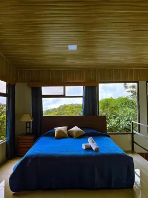 a bedroom with a blue bed with two towels on it at Cabaña Elvira in La Cruz