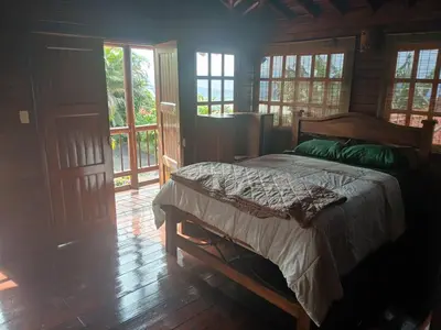 a bedroom with a bed in a room with windows at San Luis cabin in Grecia