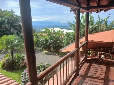 a balcony of a house with a view of the ocean at San Luis cabin in Grecia