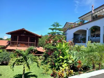 a house with palm trees in front of it at San Luis cabin in Grecia