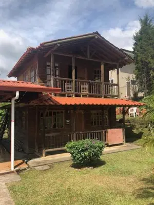 a large wooden house with a balcony in the yard at San Luis cabin in Grecia