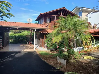 a house with a palm tree next to a driveway at San Luis cabin in Grecia