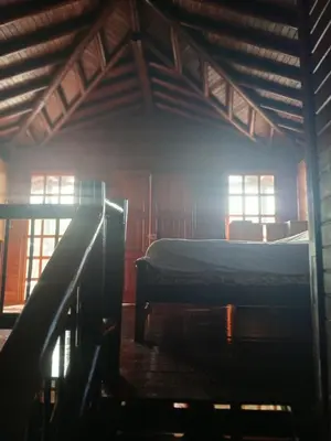 an attic room with two beds and windows at San Luis cabin in Grecia
