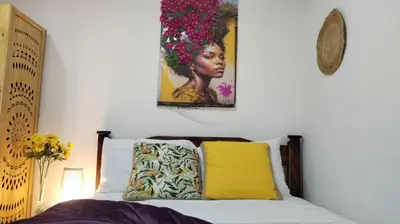 a bedroom with a bed with a painting on the wall at Habitaciones Smith in San José