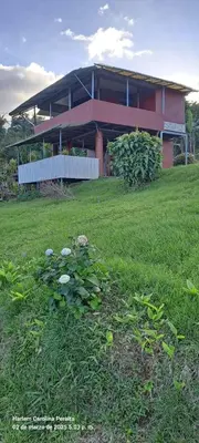 a house with a green field in front of it at cabaña Carol in Rio Celeste