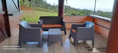 a porch with two chairs and a table and a chair at cabaña Carol in Rio Celeste