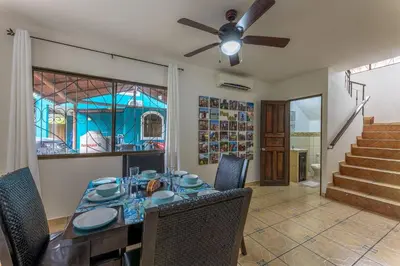 a dining room with a table and a ceiling fan at Sunset Villa, comfortable house steps from the beach in Bejuco