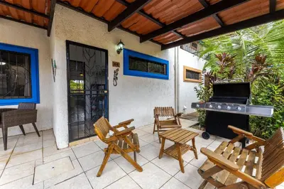 a patio with chairs and a grill and a piano at Sunset Villa, comfortable house steps from the beach in Bejuco