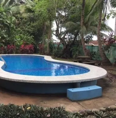 a swimming pool in a yard with aroundscribedscribedscribedscribedscribedscribedscribed at Sunset Villa, comfortable house steps from the beach in Bejuco