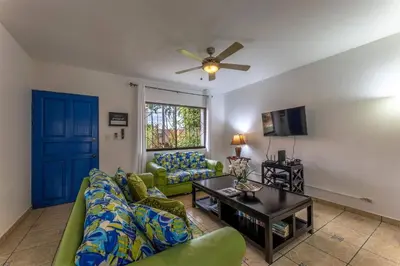 a living room with a couch and a table at Sunset Villa, comfortable house steps from the beach in Bejuco