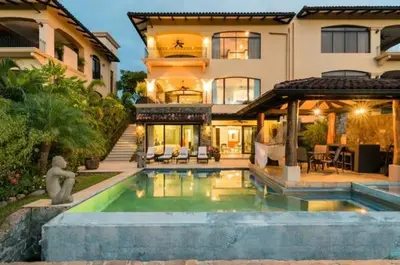 a house with a swimming pool in front of a house at Casa Serena Luxury Retreat in Reserva Conchal in Brasilito