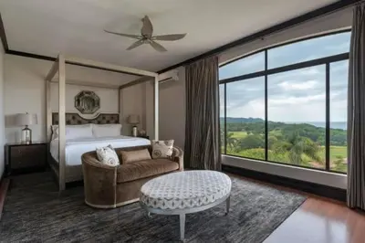 a bedroom with a bed and a large window at Casa Serena Luxury Retreat in Reserva Conchal in Brasilito