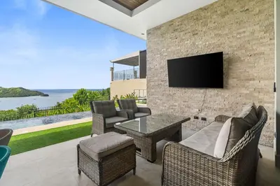 a living room with a tv on a brick wall at Luxury Ocean View Villa in Playa Hermosa