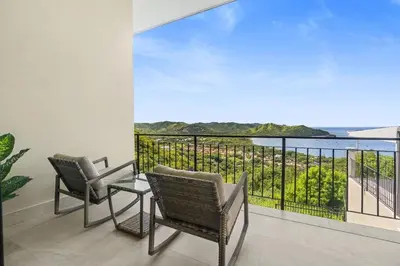 a balcony with chairs and a view of the ocean at Luxury Ocean View Villa in Playa Hermosa