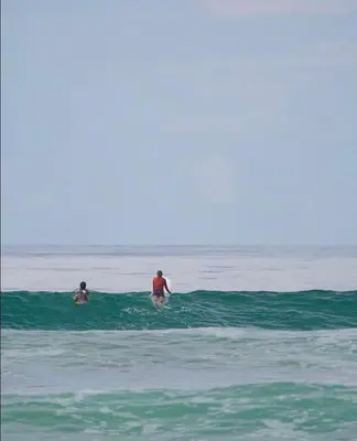 two people are in the water in the ocean at Santa Hermosa Honey moon Villa in Santiago