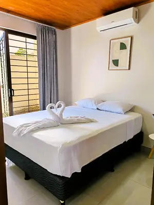 a bedroom with a bed with white sheets and a window at Fortuna River Way Apartments in Fortuna