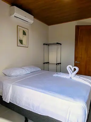 a bedroom with a bed with white sheets and a door at Fortuna River Way Apartments in Fortuna