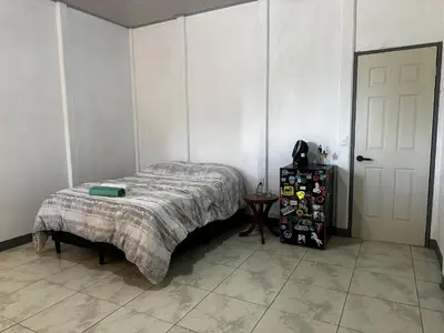 a bedroom with a bed and a table and a door at Aura Living in La Garita