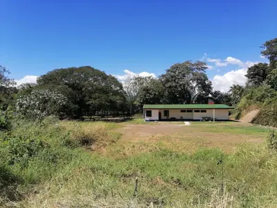 a building in a field with trees in the background at Aura Living in La Garita