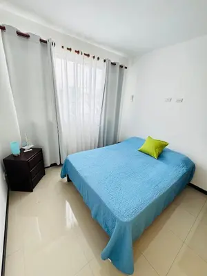 a bedroom with a blue bed with a green pillow at Family home in Bejuco with pool and beach access in Bejuco