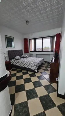 a bedroom with a bed and a checkered floor at Hotel Valladolid in Heredia