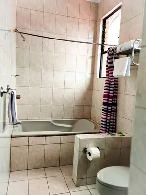 a bathroom with a tub and a toilet at Hotel Valladolid in Heredia
