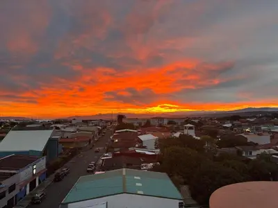 a view of a city with a sunset at Hotel Valladolid in Heredia