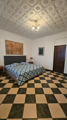 a bedroom with a bed and a checkered floor at Hotel Valladolid in Heredia