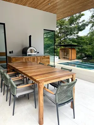 a wooden table and chairs in a kitchen with a stove at Casa McCash in Tamarindo