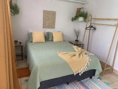 a bedroom with a bed with a green comforter at Rincón Poeta in San Ramón