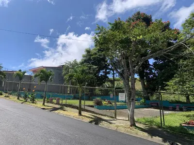 a fence with a tree on the side of a road at Rincón Poeta in San Ramón
