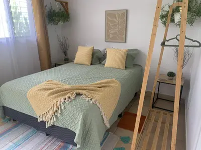 a bedroom with a bed with a green comforter at Rincón Poeta in San Ramón